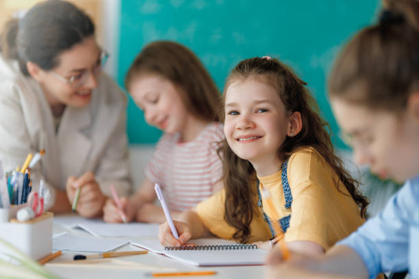 istock Happy kids and teacher at school 2165815762
