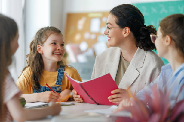 istock Happy kids and teacher at school 2165815805