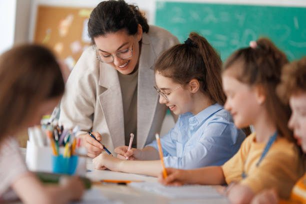 istock Happy kids and teacher at school 2165815807
