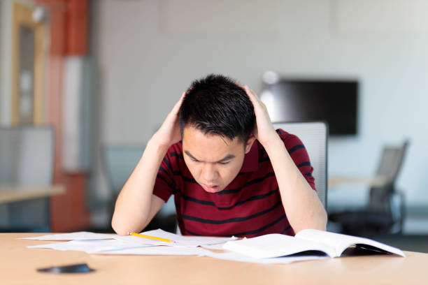 istock A college student collapsing under homework and exam pressure 2165816371