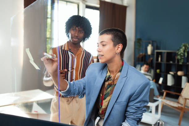 istock Two young employees combining efforts in their work environment 2165819679