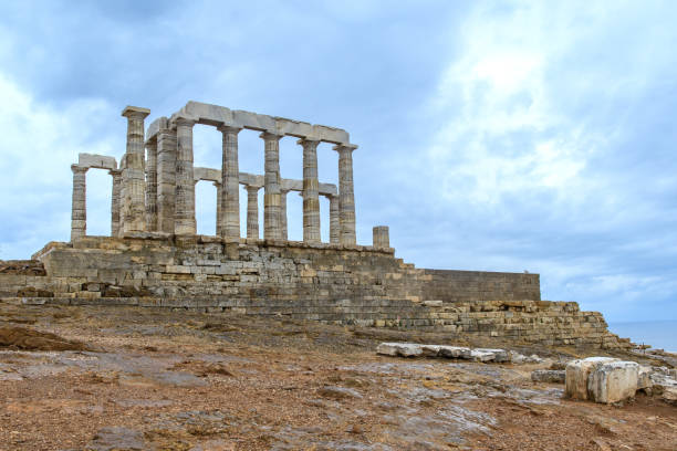 Cape Sounion, Greece - October 7, 2019: Ancient Temple of Poseidon ruins under dramatic sky.