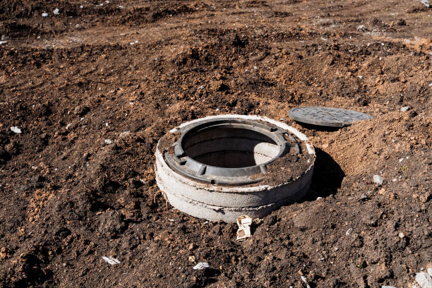 istock Concrete manhole cover on construction site surrounded by exposed soil and earth. Part of urban infrastructure development project. Essential for maintenance of underground utility network 2165820424