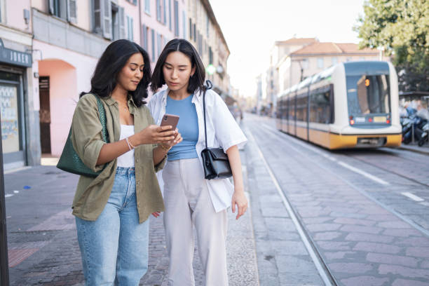 istock Two friends exploring Milano with a smartphone on a sunny day 2165821853