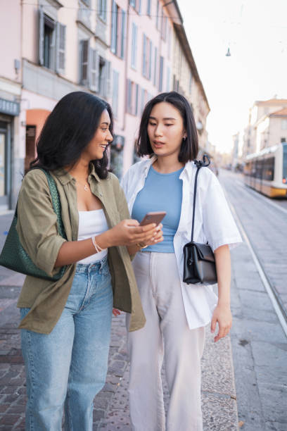 istock Two friends exploring Milano together and looking at a smartphone 2165821864