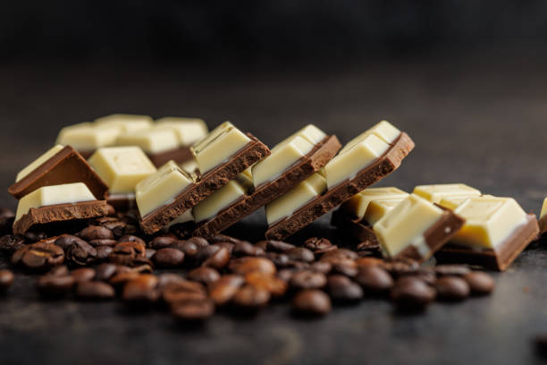 istock White light dark chocolate bars and coffee beans on black table. 2165821952
