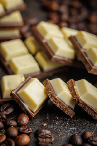 istock White light dark chocolate bars and coffee beans on black table. 2165822048