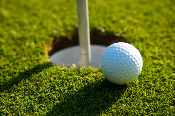 istock Closeup Golf ball on green grass on course 2165823115