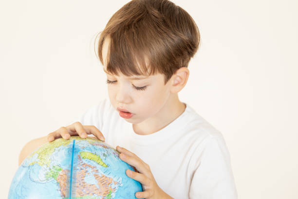 istock 6 year old boy studying globe in geography class 2165823712