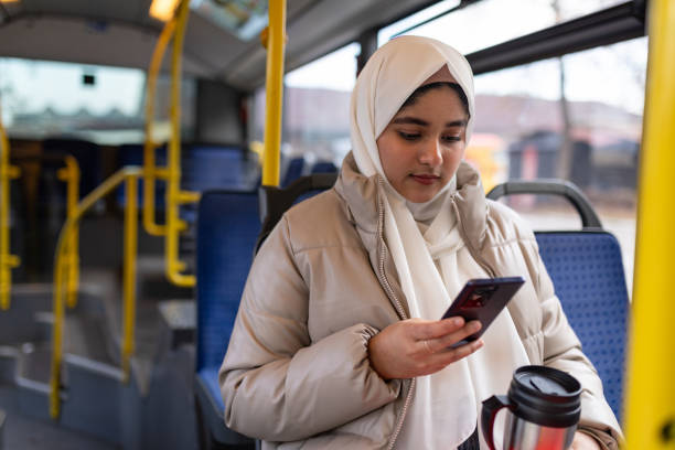 istock Young woman riding in a bus and using her phone 2165827611
