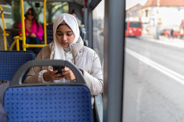 istock Young woman riding in a bus and using her phone 2165827653