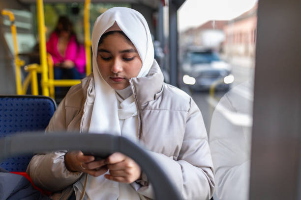 istock Young woman riding in a bus and using her phone 2165827659