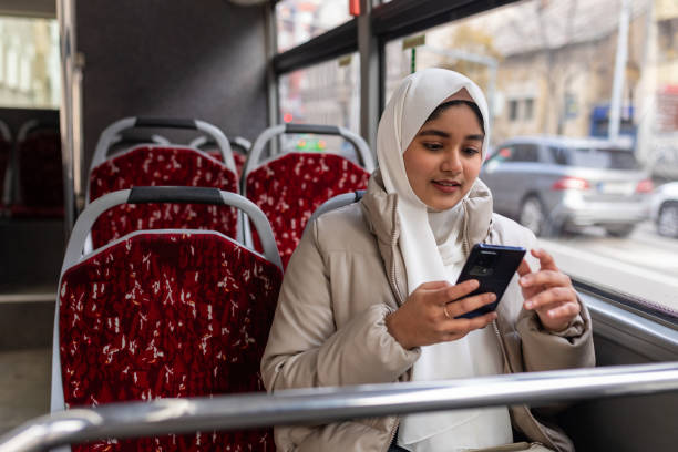 istock Young woman riding in a bus and using her phone 2165827721