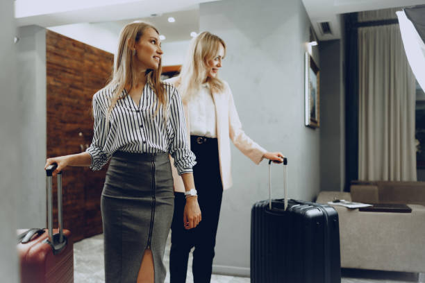 istock Two young women in formal clothes entering hotel lobby 2165829580