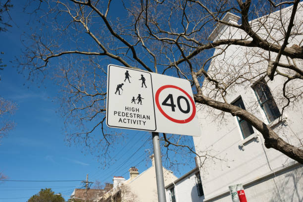 Speed limit and high pedestrian activity zone sign on a pole on a sunny day.