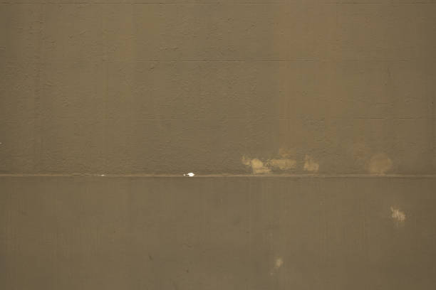 Part of a painted textured concrete wall with signs of repair.