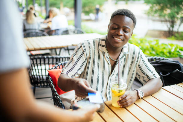 istock Young man paying with credit card in a cafe 2165830199