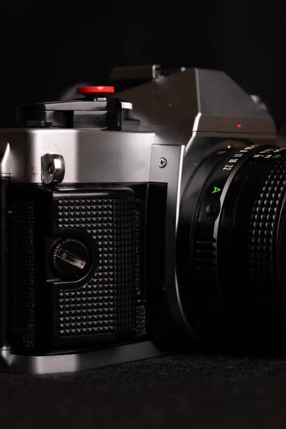 istock Vertical shot focusing on an antique film camera with a black backdrop, emphasizing its classic design and nostalgic feel. 2165830301