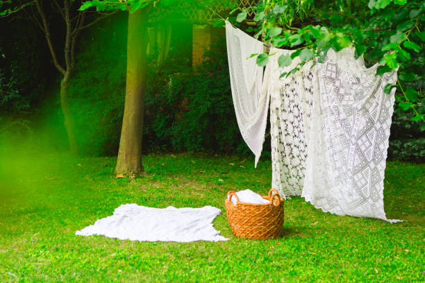 istock White laundry on clothesline in garden. White curtains drying in the sun. 2165831003