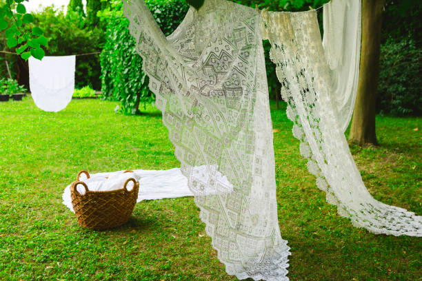 Washing day with laundry on clothesline, White clean sheets outdoors. Drying on a rope on background of beautiful scenery in the sun