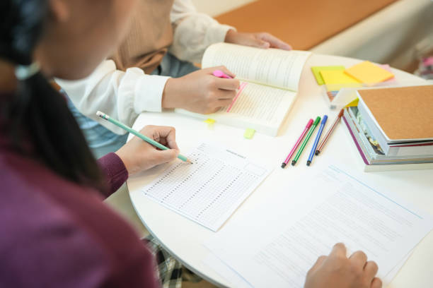 istock Learning with friends Young students campusHigh School Tutor for examining helps school homework together withÂ friend catching up and learning 2165831258