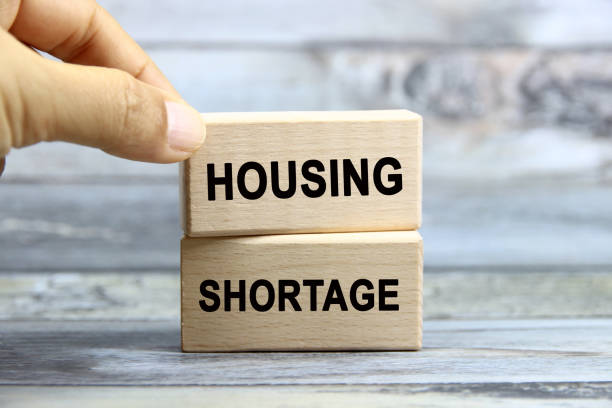 istock housing shortage wording  or text on wood block with hand.Grey wooden background.Copy space and business concept. 2165840310