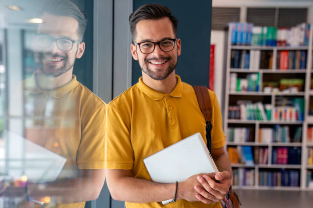 istock Smiling Caucasian Male Student with Tablet by Library Window 2165841773