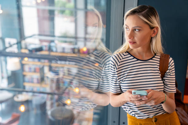 istock Positive Caucasian Female Student Texting by Library Window 2165842332