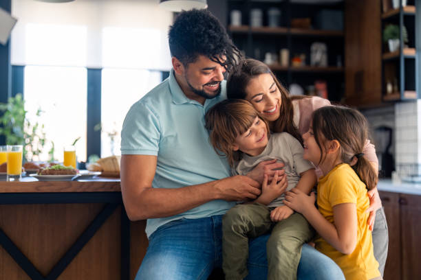 istock Joyful Family Embracing in Sunny Kitchen 2165843156