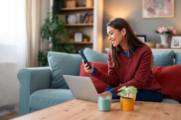 istock Smiling Woman Multitasking with Technology at Home 2165843341