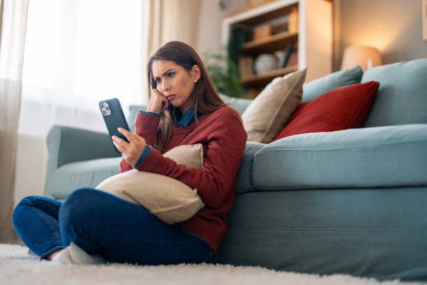 istock Uneasy Woman with Smartphone on Couch 2165843400
