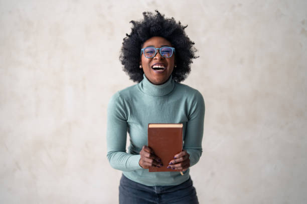 istock Educated Black Woman Presenting Book with Confidence 2165844092
