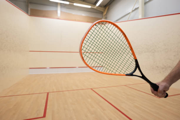 istock Male arm holding a squash racket inside court 2165845781