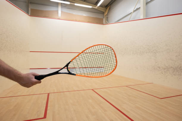 istock Male arm holding a squash racket inside court 2165845782