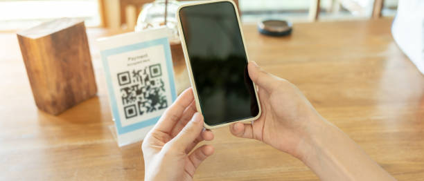 istock Woman use smartphone to scan QR code for order menu in cafe restaurant with a digital delivery. Choose menu and order accumulate discount. E wallet, technology, pay online, credit card, bank app. 2165846305