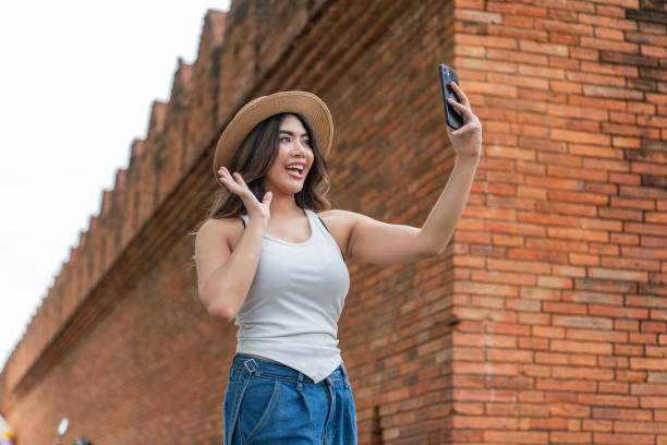 istock Asian Woman Using Phone to Selfie at Tha Phae Gate, Chiang Mai 2165846594
