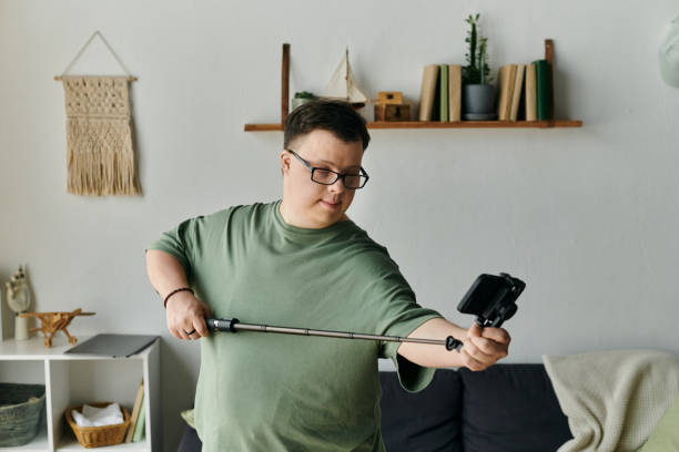 istock Joyful young man with down syndrome taking a selfie at home during leisure time 2165849653