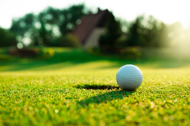 Professional golfer demonstrates focus and skill at a golf resort, ready for an intense game. The sportsman is captured mid-swing with a golf club.