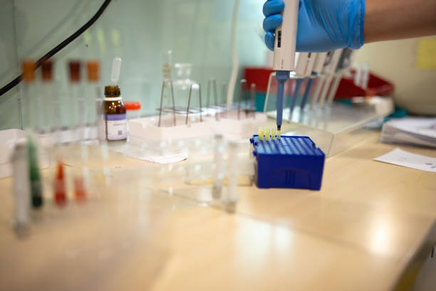 A young Caucasian laboratory technician using a pipette and test tube in a laboratory