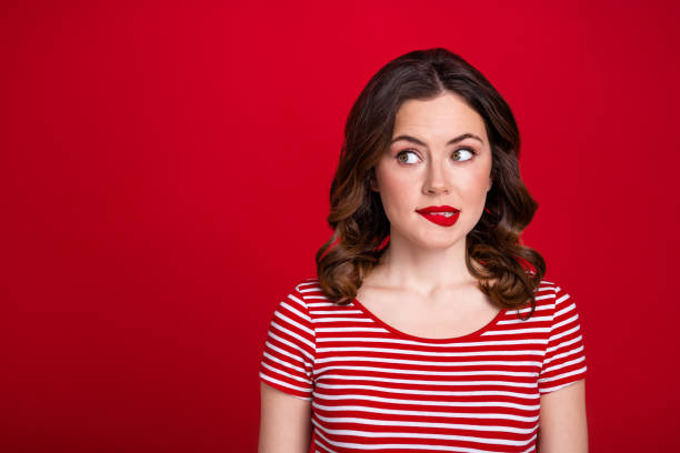 Photo of pretty cute girl look empty space bite red lip made bad thing expect scolding isolated red maroon color background Photo of pretty cute girl look empty space bite red lip made bad thing expect scolding isolated red maroon color background. woman stealth stock pictures, royalty-free photos & images