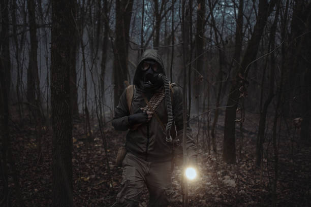 istock A man in camouflage with a flashlight walks through the smoke through a dark forest. Front view. 2165870257