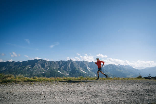 istock Trail runner bounds along mountain road 2165872728