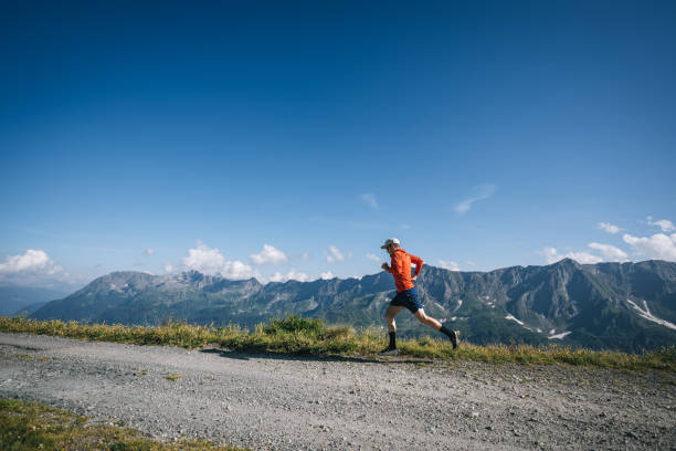 istock Trail runner bounds along mountain road 2165872731