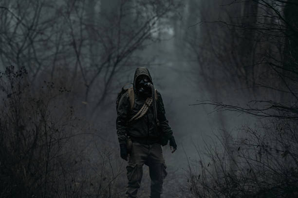 istock A man in camouflage in a post-apocalyptic, smoky, dark forest. Front view. 2165872884