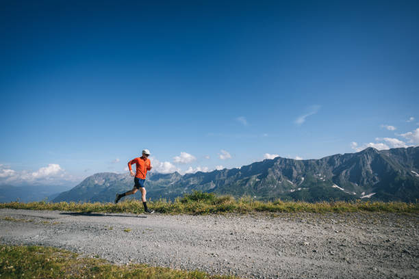 istock Trail runner bounds along mountain road 2165872894