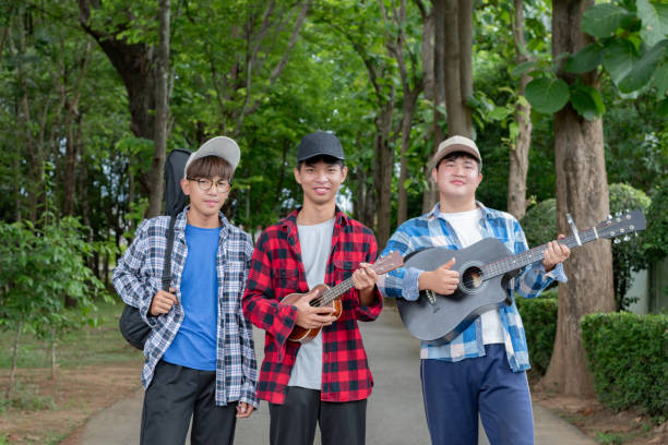Young asian boys walking along way in public park together, soft and selective focus, concept for teen lifestyle and teenagers's spending times.
