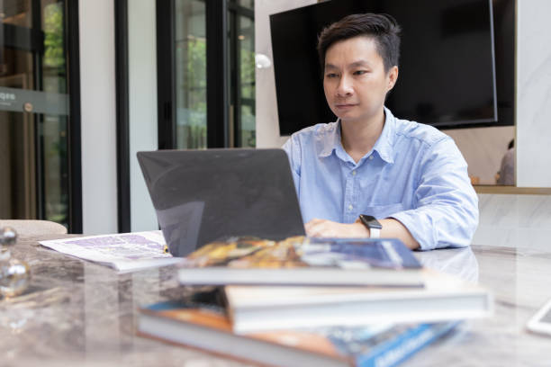 istock Smiling Man Working on Laptop at Desk 2165873485