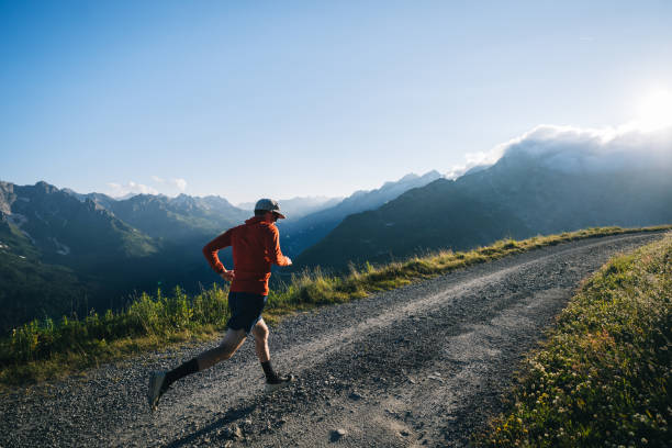 istock Trail runner bounds along mountain road 2165874229