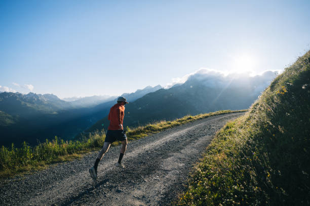 Trail runner bounds along mountain road