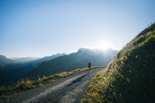istock Trail runner bounds along mountain road 2165874395